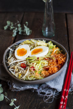 Bowl of gluten free Udon noodle soup with carrots, Chinese cabbage, zoodles, mungo beans sprouts and boiled egg