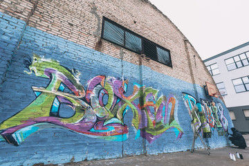street artist painting colorful graffiti on wall