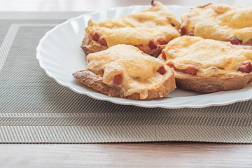 close-up of baked hot sandwiches with cheese and sausage on white plate