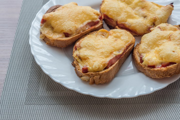 close-up of baked hot sandwiches with cheese and sausage on white plate