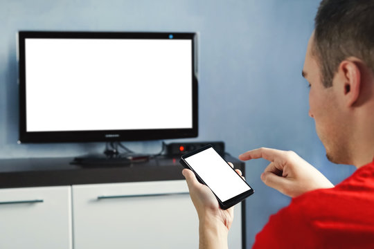 Relaxed Man With Smartphone Connected To A Tv And Copy Space