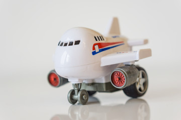 Closeup of white plastic toy airplane on a white table.