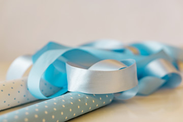 Gift wrapping, close-up paper, gift boxes, ribbons and scissors on a white background. Shallow depth of focus. Concept holidays.