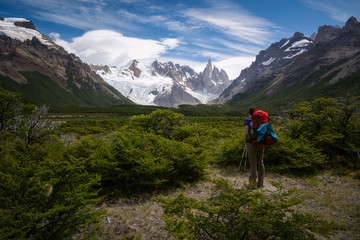 Young female is looking at the Cerro Torre in Los Glaciares National park in Patagonia region in Argentina