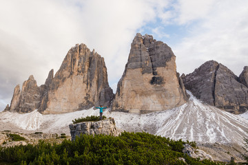 Young female appears very small in regards to Tre Cime di Lavaredo in the Dolomites in Italy