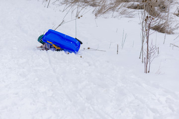 Winter story, slide and child under a sled.