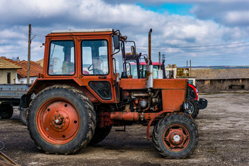 Fototapeta premium Closeup of an old tractor after plowing. Wheels covered with mud. Agronomy, agriculture,concept.