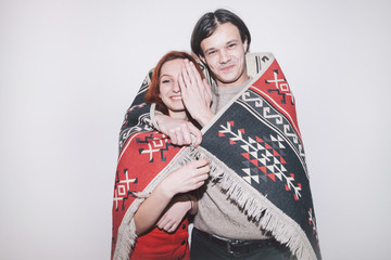 boy and girl wrapped into warm plaid on white background