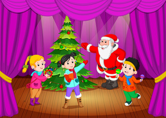 Obraz na płótnie Canvas santa claus on the stage with kids singing