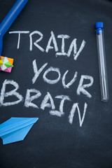 Train your brain inscription on a blackboard