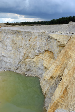 view into a limestone quarry with water on ground.