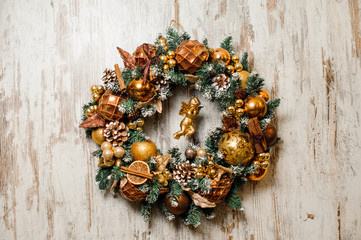 Beautiful Christmas wreath made of fir tree and decorated in golden tones