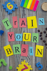 Train your brain inscription on a wooden background
