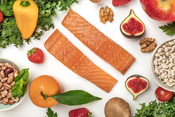 Vibrant fresh food, vegetables, fruits, legumes, fish on white