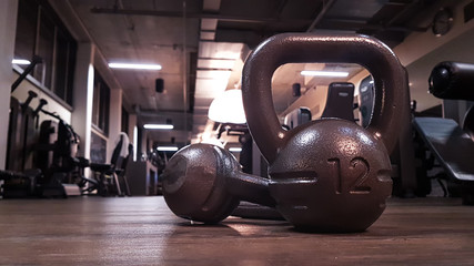 Fototapeta premium Kettlebells in gym on the floor with blurred background