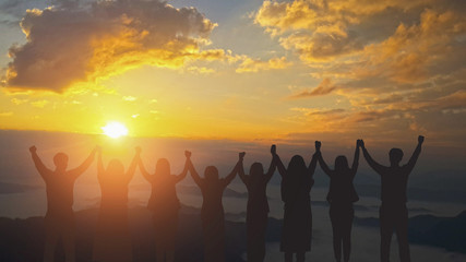 Fototapeta na wymiar Silhouette image of happy teamwork join hands together up to the beautiful sky, successful business from good partnership and colleagues.