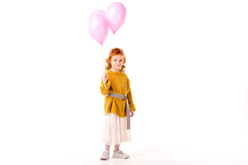 happy red hair child holding pink balloons isolated on white