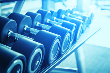 Rows of dumbbells in the gym with hign contrast and monochrome color tone