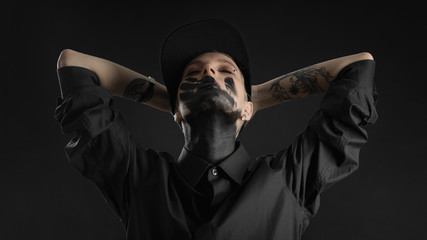 woman in black shirt and hat with black trace of hand on face