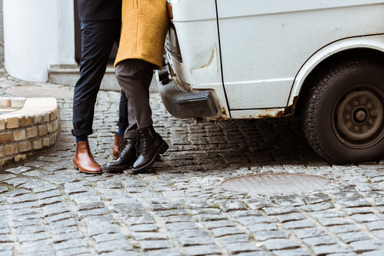 cropped image of couple in autumn outfit hugging beside car