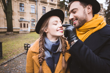 happy beardman touching nose of his girlfriend by finger