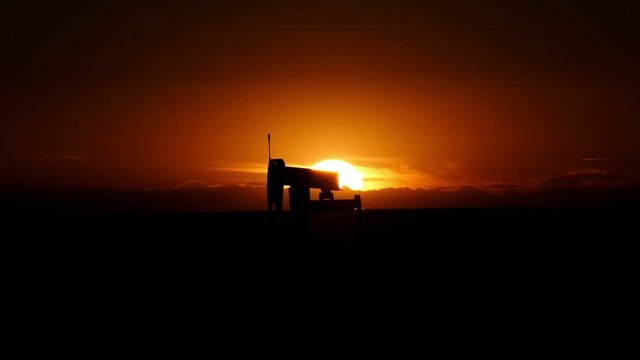 Oil well and pump jack under a Texas sunset