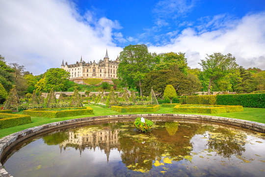 Scenic Dunrobin Castle fountain reflecting the Dunrobin castle in the garden park that surrounds it. Scottish Highlands, Scotland, United Kingdom.