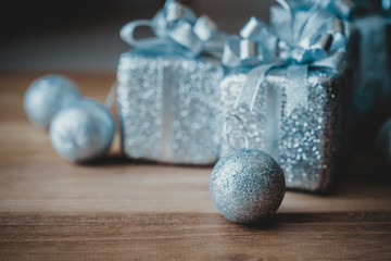Closeup image of silver present boxes and Christmas decorations on wooden background