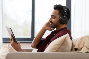 man in phones with tablet pc listening to music