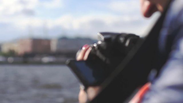 Young woman on a river tour, taking photos, using camera in slow motion. City view of St Petersburg. 3840x2160