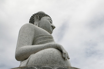 Big Buddha monument against cloudy sky background