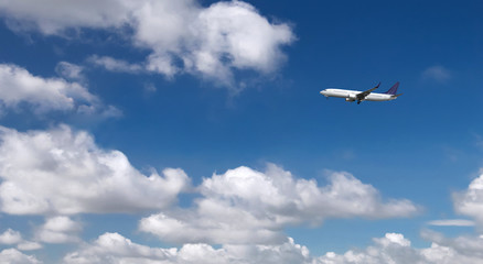 Fototapeta na wymiar Commercial passenger airplane landing or taking off from the airport with blue cloudy sky in the background