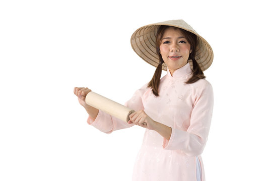 beautiful woman in pink dress and vietnam hat holding rolling pin. isolated background with clipping path.