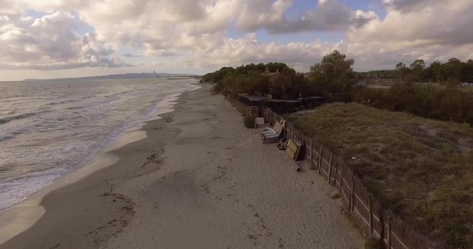 Aerial, beautiful empty sand beach and sea waves on a cloudy day