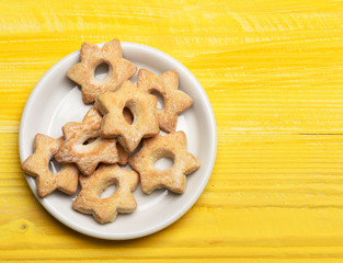 Star shaped biscuits lying on white plate. Homemade pastry