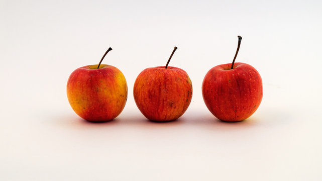 Три маленьких яблока на белом фоне.