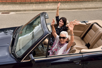 women of different generations happy in a convertible car