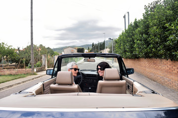 two happy women with convertible car