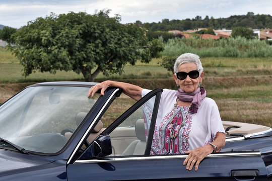 Portrait Of A Senior Woman With Convertible Car