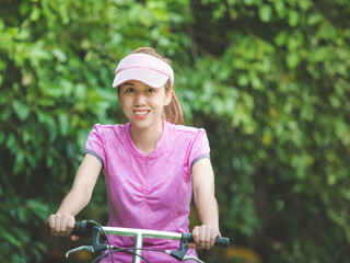 Asian cute woman relaxing with riding bicycle in outdoor park