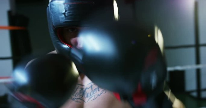 Professional young boxer in the ring, will practice the technique of strikes, struts, protection and endurance, blue eraser bandages, in camera. Concept: love of sport, young boxers, love of victory.
