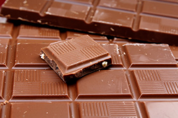 Chocolate bars as background. Milk and dark shiny chocolate texture. Stack chocolates pattern. Stunning beautiful cacao brown dessert sweets.