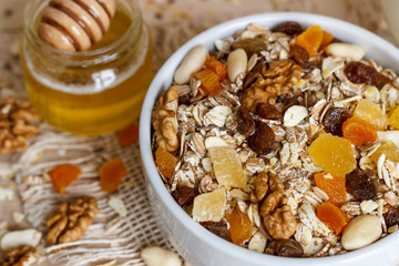 Healthy eating. On the wooden board are muesli, honey in a jar close-up.