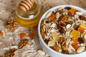 Healthy eating. On the wooden board are muesli, honey in a jar, a banana, an orange, a glass of milk.