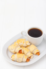 Freshly baked croissant, jam, cup of black coffee on white wooden background. Homemade cookie. Fresh pastries for breakfast. Delicious dessert. Closeup photography. Horizontal banner