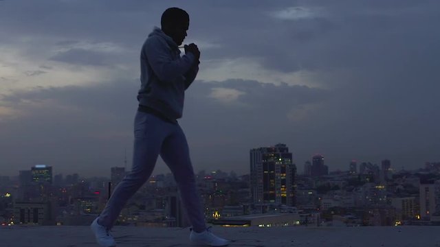 Strong and courageous guy fearlessly overcoming difficulties, shadow boxing