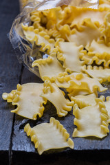 Mafaldine Nudeln auf dunklem rustikalen Holz