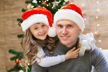 Dad and daughter, Christmas hat, tree, gift box