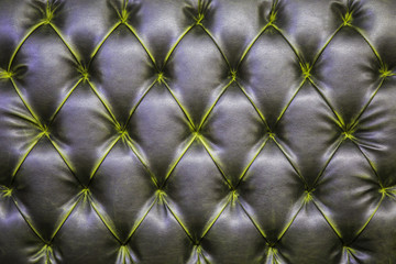 Leather sofa texture background. ?he black gray quilted modern leather pattern