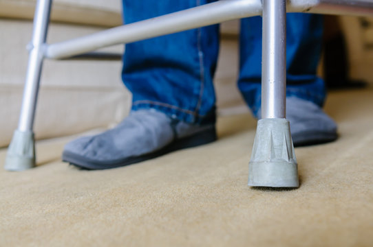 Elderly Man Using A Zimmer Walking Frame In His Own Home